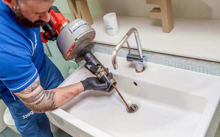 Plombier effectuant un débouchage de lavabo à Bruxelles