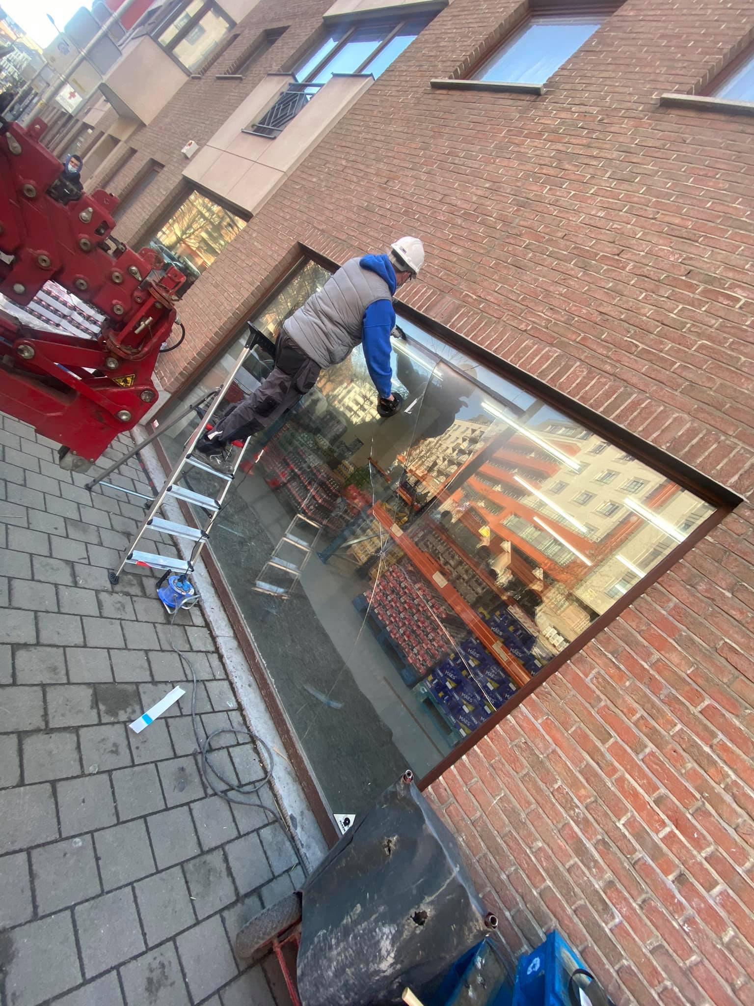 Artisans terminant la pose d'une vitrine de magasin à Bruxelles